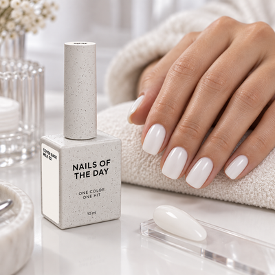 Cover Base Milk 02 Nails Of The Day 10 ml apresentada numa mesa profissional de manicure com unhas em branco leitoso