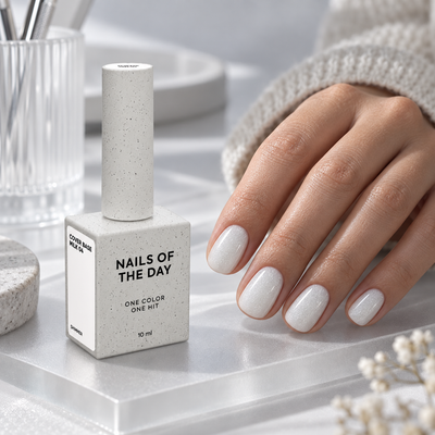 Cover Base Milk 04 Nails Of The Day 10 ml apresentada numa mesa profissional de manicure com unhas em branco leitoso com shimmer prateado